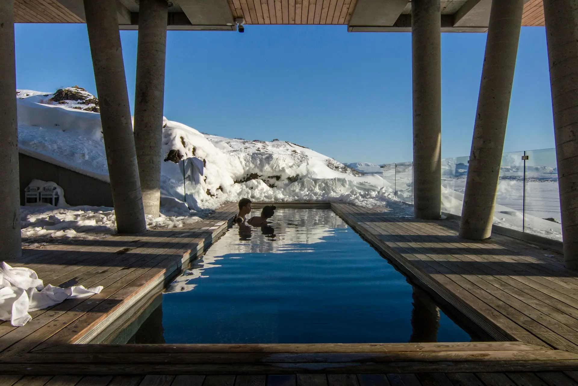 two person taking bath on pool with distance to glacier mountain during daytime